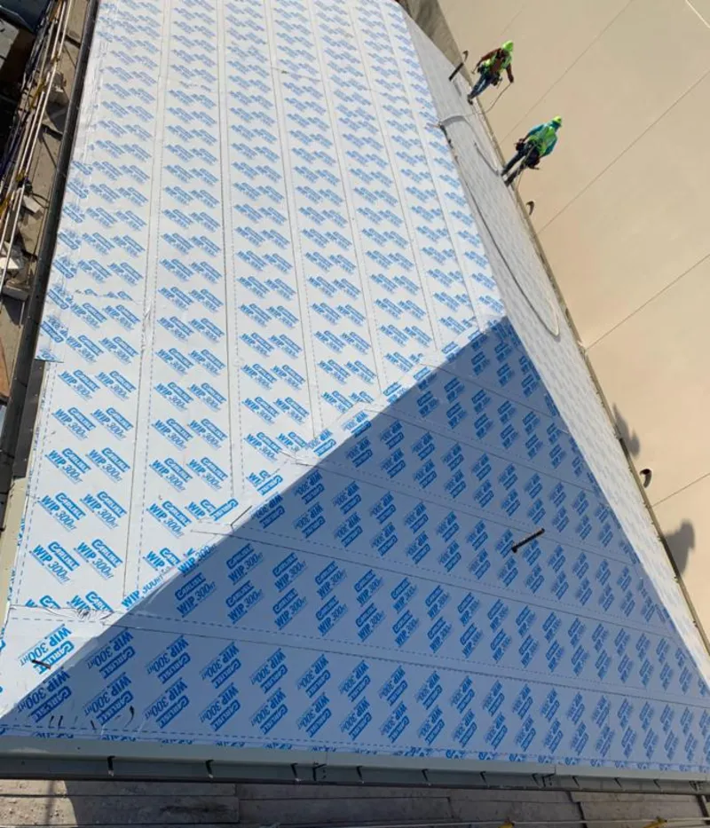 Professional roofers installing underlayment on a metal roof in Carrollton